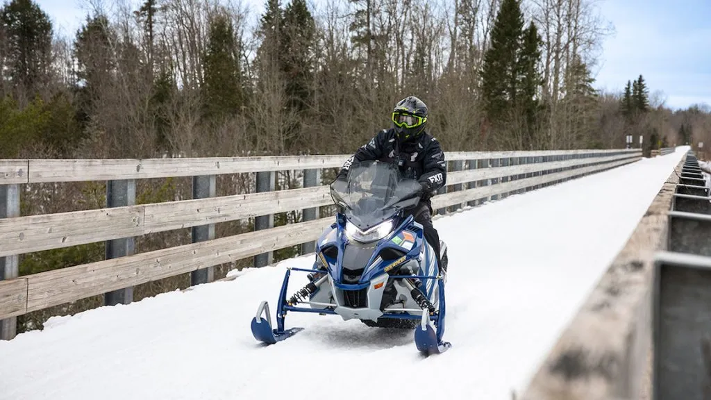 snowmobile with person riding in snow