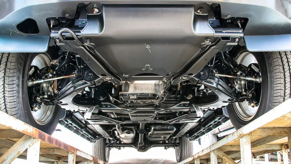 Bottom view of a vehicle undercarriage on a ramp.